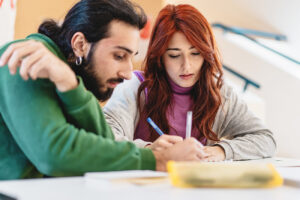 Two colleagues discuss and jot down ideas, deeply engaged in a collaborative effort, sharing insights and strategies.